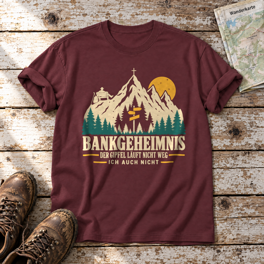 Bankgeheimnis – T-Shirt Unisex in Bordeaux, flach liegend auf alten Holzbrettern mit Wanderschuhen und Wanderkarte.