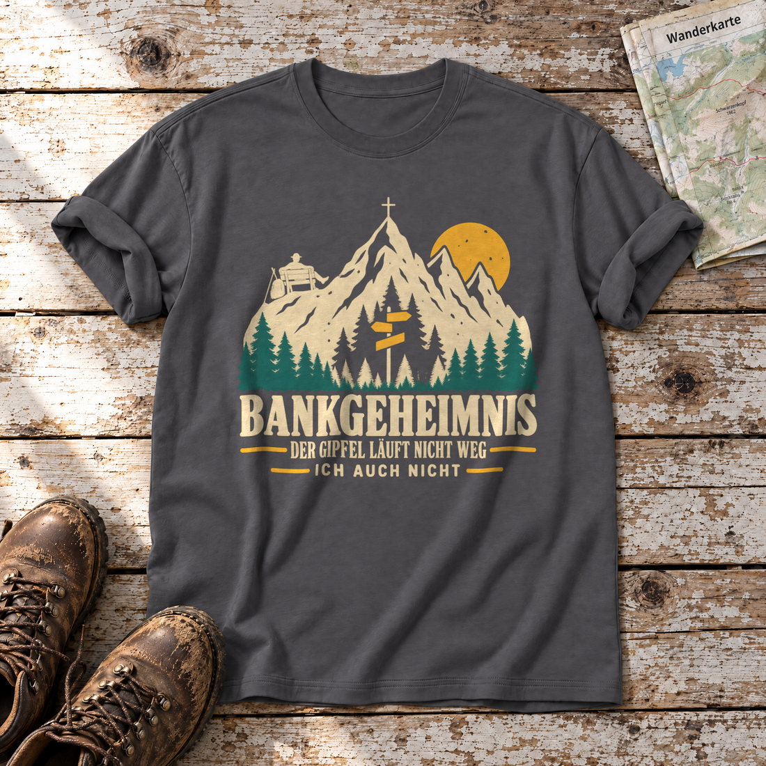Bankgeheimnis – T-Shirt Unisex in Dunkelgrau, flach liegend auf alten Holzbrettern mit Wanderschuhen und Wanderkarte.