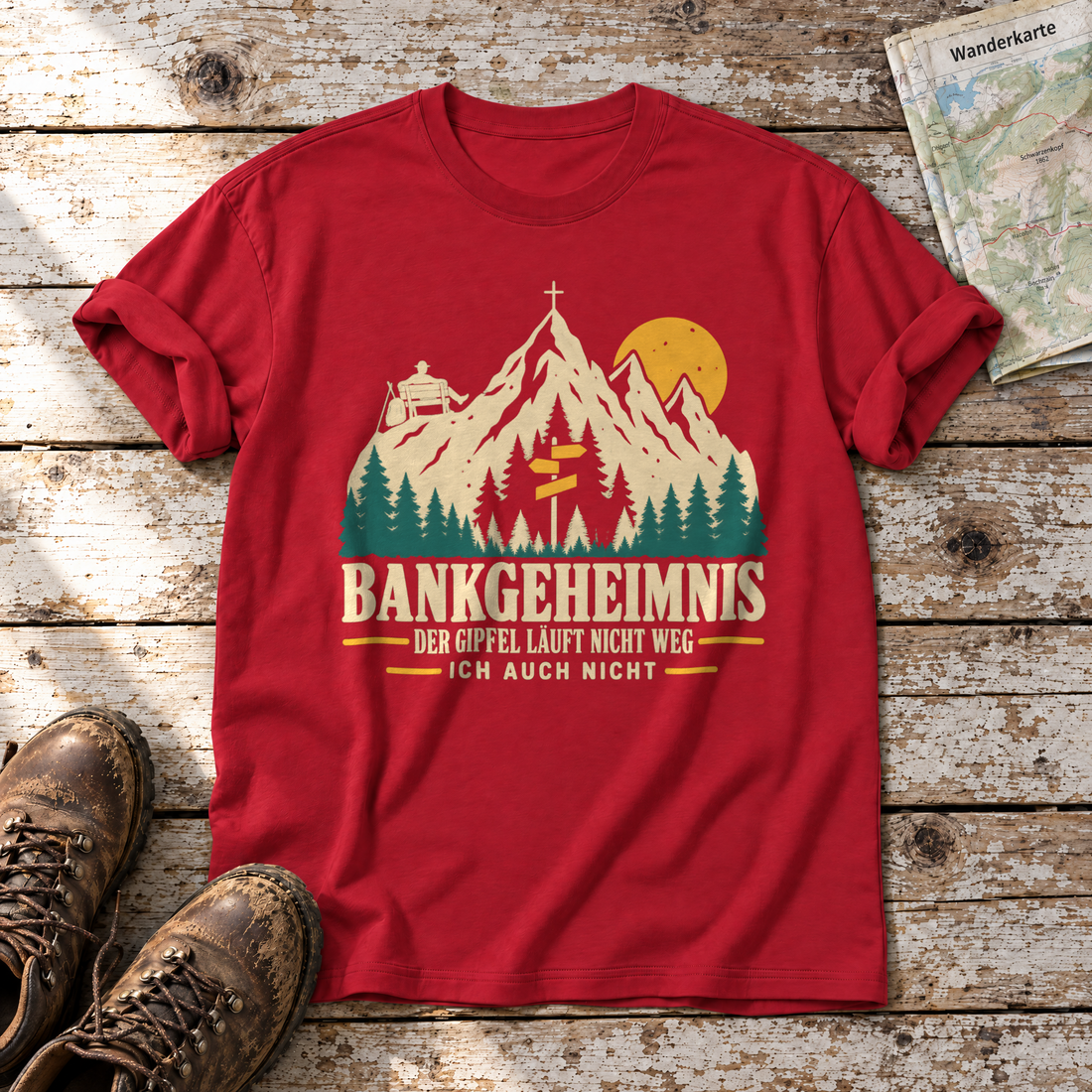 Bankgeheimnis – T-Shirt Unisex in Rot, flach liegend auf alten Holzbrettern mit Wanderschuhen und Wanderkarte.