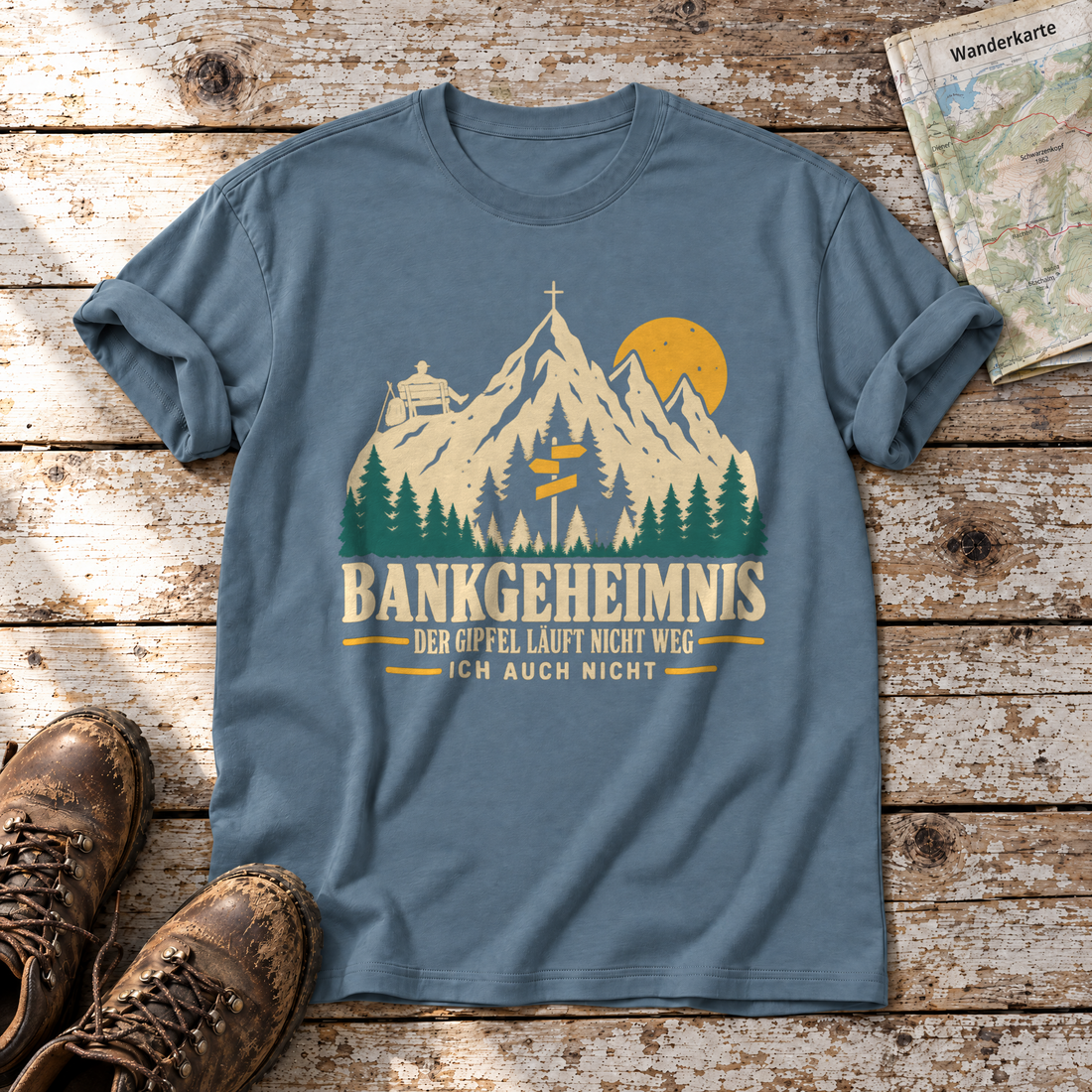 Bankgeheimnis – T-Shirt Unisex in Steinblau, flach liegend auf alten Holzbrettern mit Wanderschuhen und Wanderkarte.