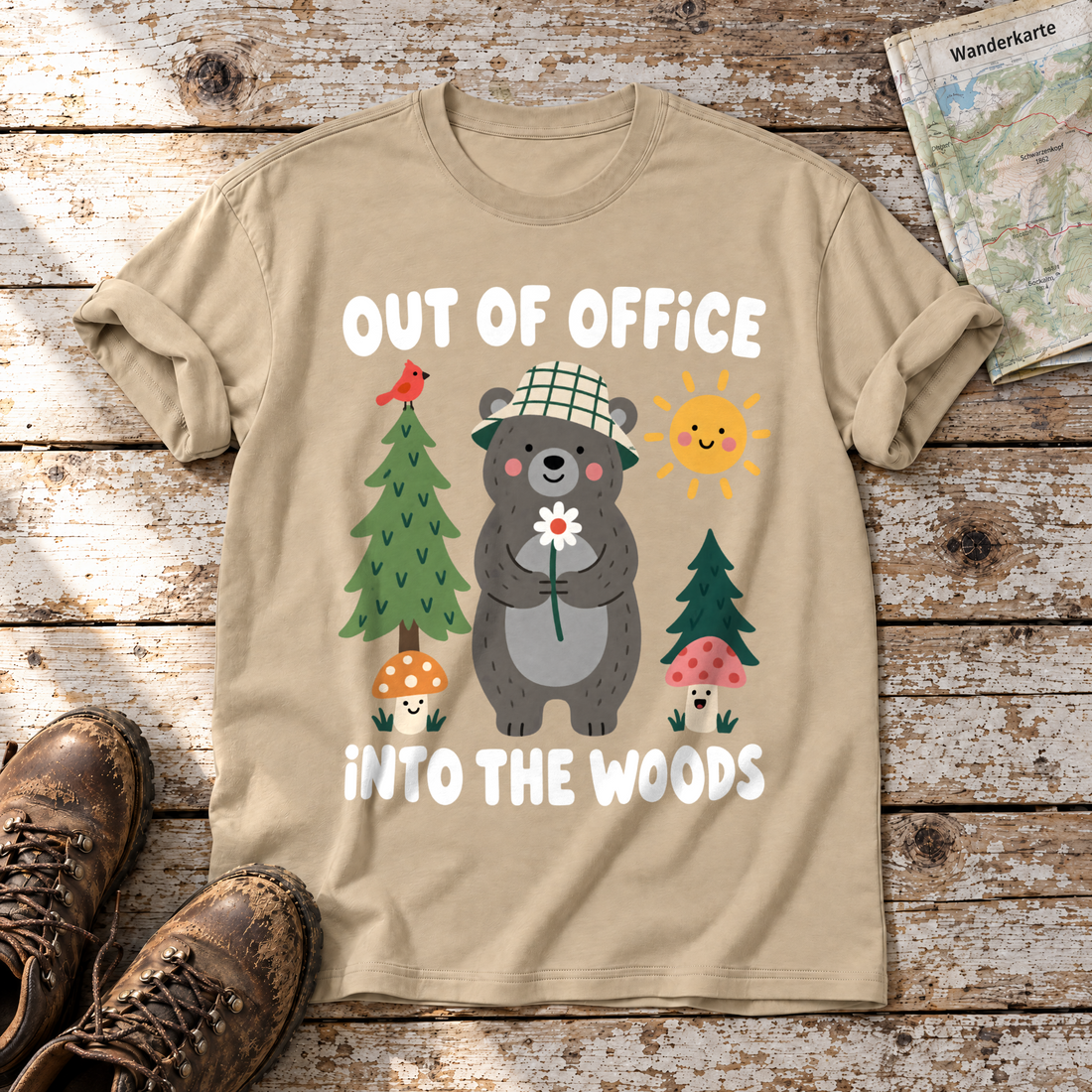 Out of Office – into the Woods – T-Shirt Unisex in Sand, flach liegend auf alten Holzbrettern mit Wanderschuhen und Wanderkarte.