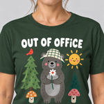 Nahaufnahme des Drucks: Out of Office – into the Woods – T-Shirt Unisex in Flaschengrün, von einer Frau getragen