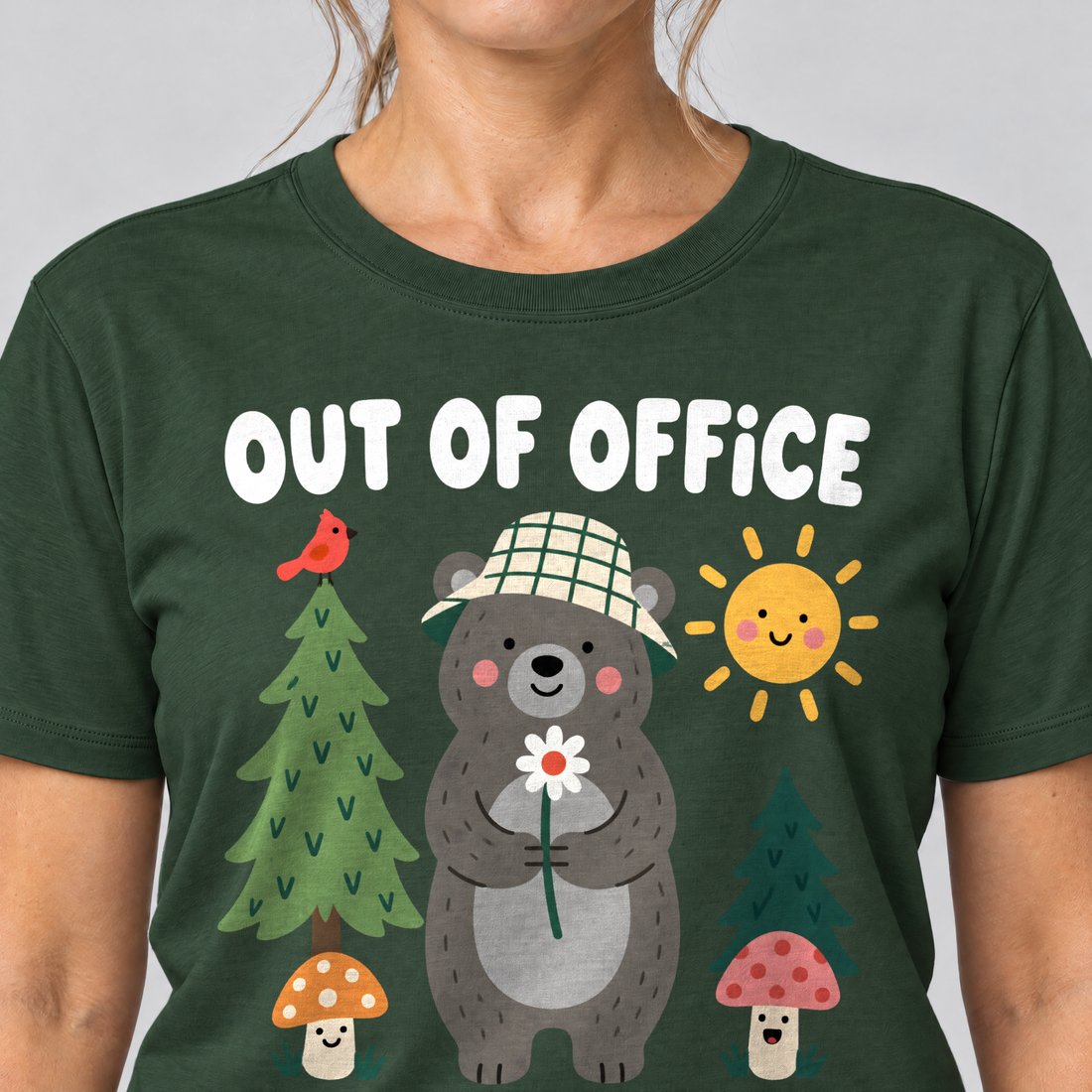 Nahaufnahme des Drucks: Out of Office – into the Woods – T-Shirt Unisex in Flaschengrün, von einer Frau getragen