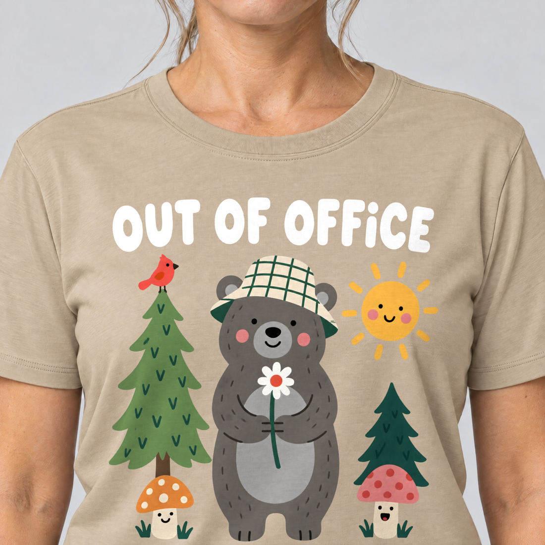 Nahaufnahme des Drucks: Out of Office – into the Woods – T-Shirt Unisex in Sand, von einer Frau getragen