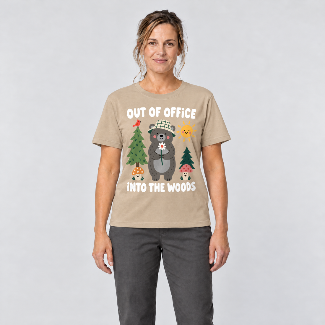 Frau trägt Out of Office – into the Woods – T-Shirt Unisex in Sand, Ansicht von vorn