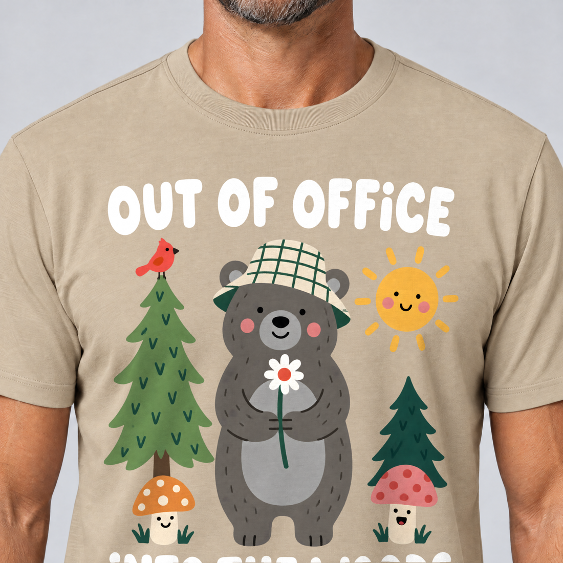 Nahaufnahme des Drucks: Out of Office – into the Woods – T-Shirt Unisex in Sand, von einem Mann getragen