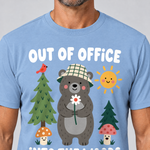 Nahaufnahme des Drucks: Out of Office – into the Woods – T-Shirt Unisex in Himmelblau, von einem Mann getragen