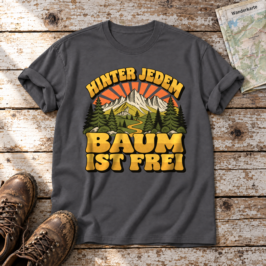 Hinter jedem Baum ist frei – T-Shirt Unisex in Dunkelgrau, flach liegend auf alten Holzbrettern mit Wanderschuhen und Wanderkarte.