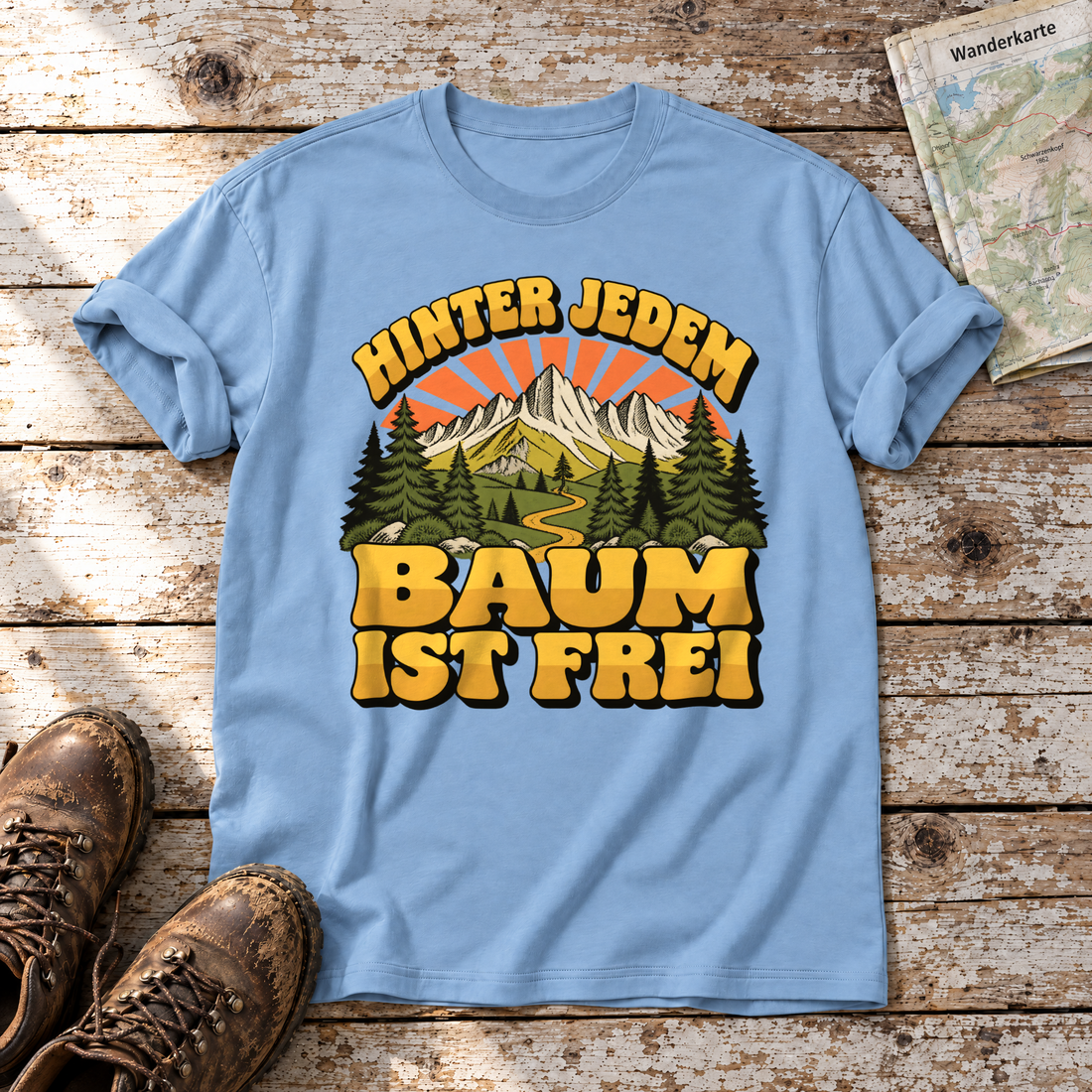 Hinter jedem Baum ist frei – T-Shirt Unisex in Himmelblau, flach liegend auf alten Holzbrettern mit Wanderschuhen und Wanderkarte.