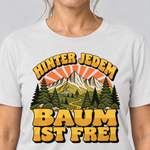 Nahaufnahme des Drucks: Hinter jedem Baum ist frei – T-Shirt Unisex in Weiß, von einer Frau getragen