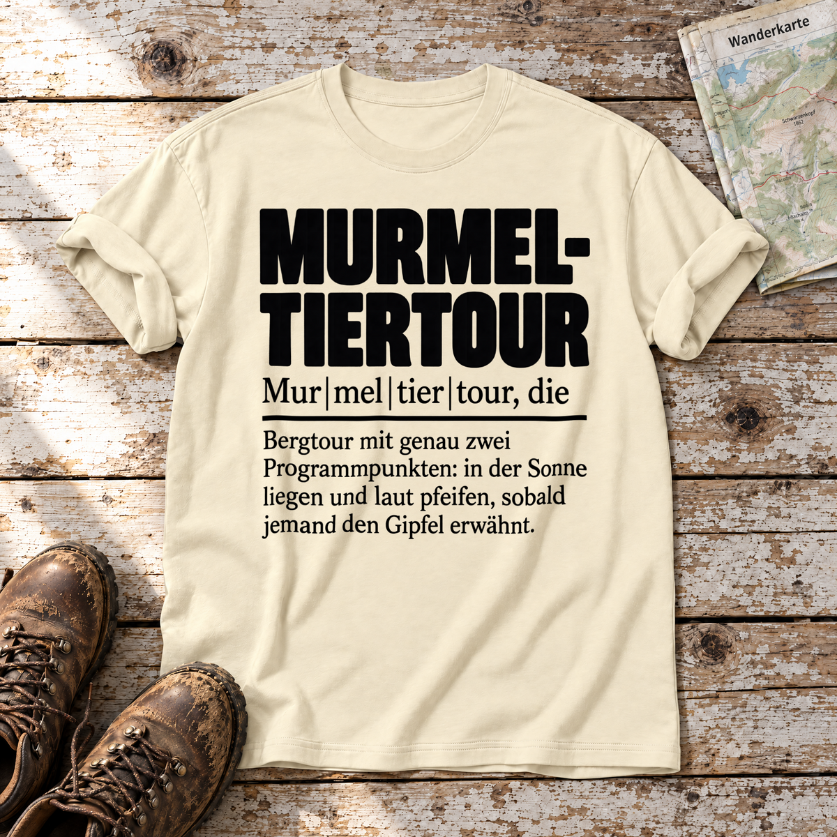 Murmeltiertour – T-Shirt Unisex in Natur, flach liegend auf alten Holzbrettern mit Wanderschuhen und Wanderkarte.