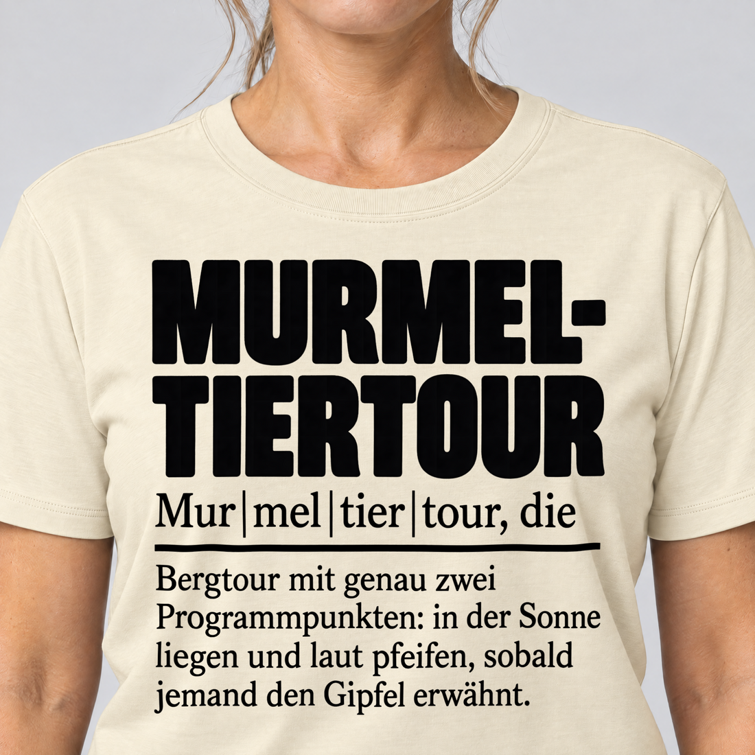Nahaufnahme des Drucks: Murmeltiertour – T-Shirt Unisex in Natur, von einer Frau getragen