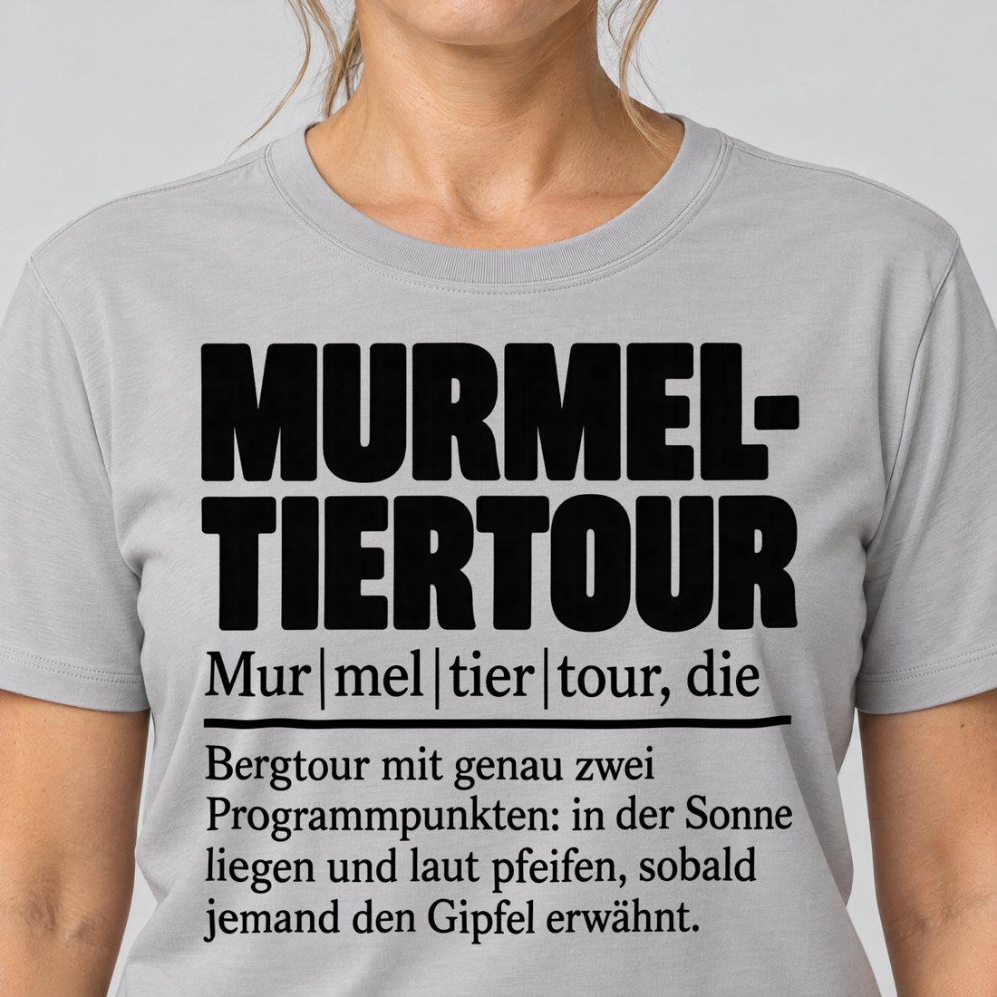 Nahaufnahme des Drucks: Murmeltiertour – T-Shirt Unisex in Hellgrau, von einer Frau getragen