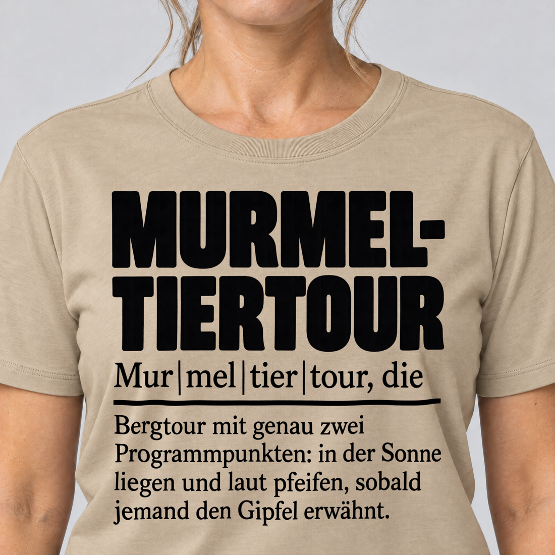 Nahaufnahme des Drucks: Murmeltiertour – T-Shirt Unisex in Sand, von einer Frau getragen