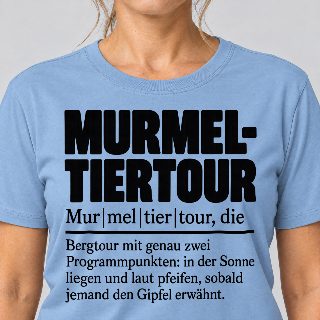 Nahaufnahme des Drucks: Murmeltiertour – T-Shirt Unisex in Himmelblau, von einer Frau getragen