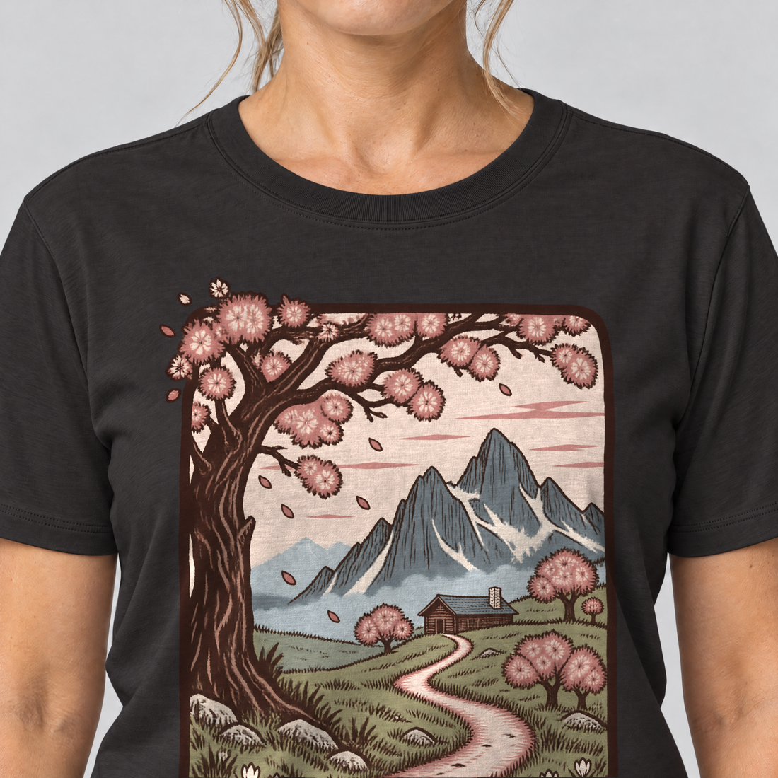 Nahaufnahme des Drucks: Almweg zur Hütte – T-Shirt Unisex in Schwarz, von einer Frau getragen