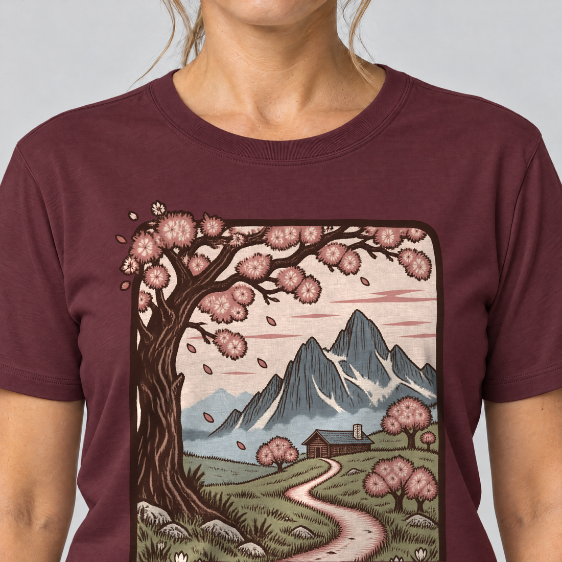 Nahaufnahme des Drucks: Almweg zur Hütte – T-Shirt Unisex in Bordeaux, von einer Frau getragen