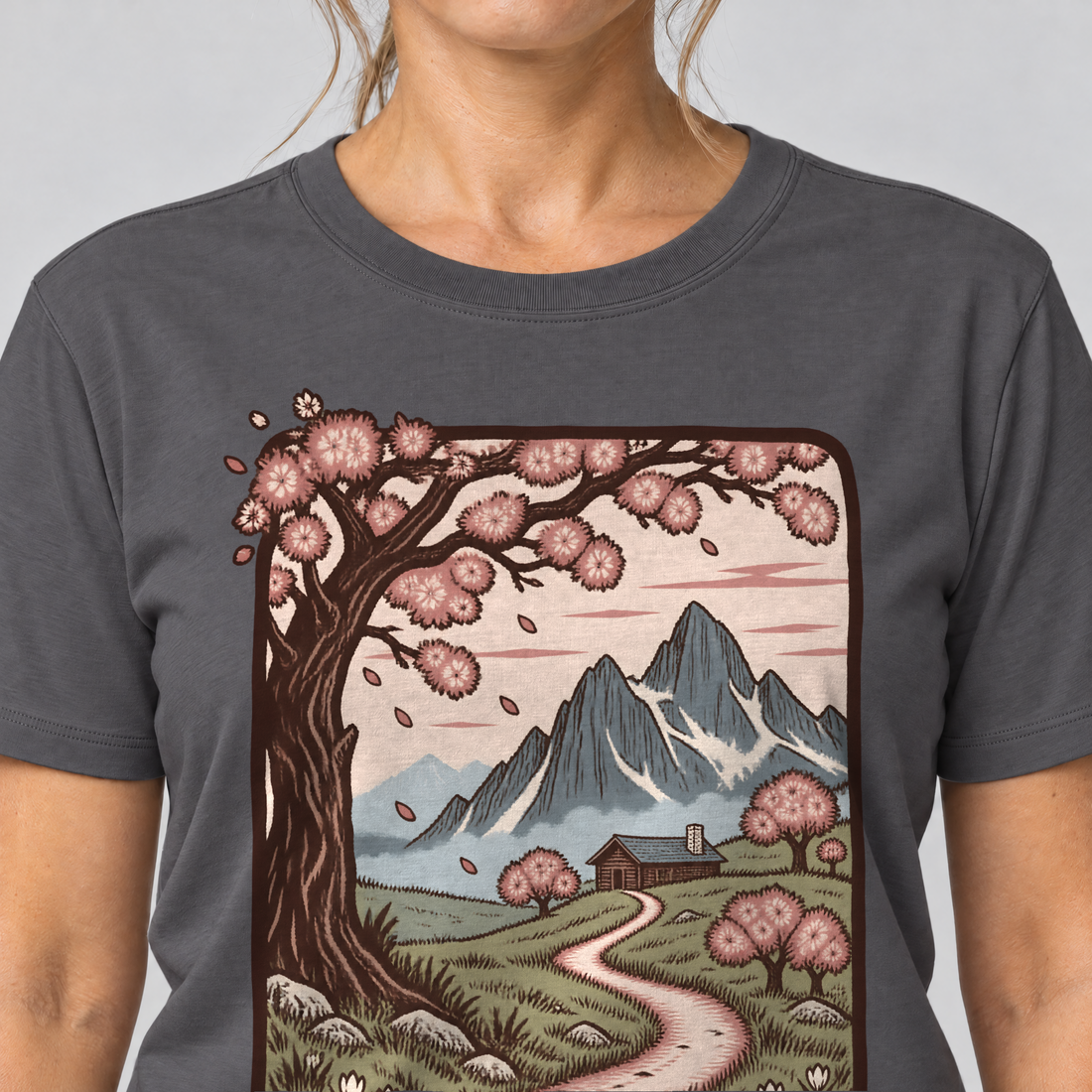 Nahaufnahme des Drucks: Almweg zur Hütte – T-Shirt Unisex in Dunkelgrau, von einer Frau getragen