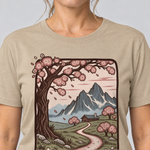 Nahaufnahme des Drucks: Almweg zur Hütte – T-Shirt Unisex in Sand, von einer Frau getragen