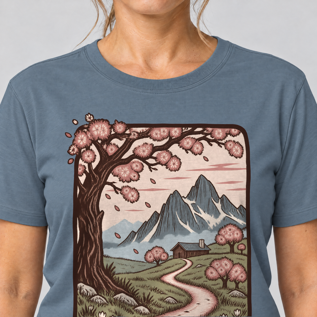 Nahaufnahme des Drucks: Almweg zur Hütte – T-Shirt Unisex in Steinblau, von einer Frau getragen