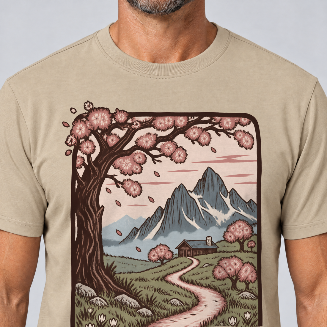 Nahaufnahme des Drucks: Almweg zur Hütte – T-Shirt Unisex in Sand, von einem Mann getragen