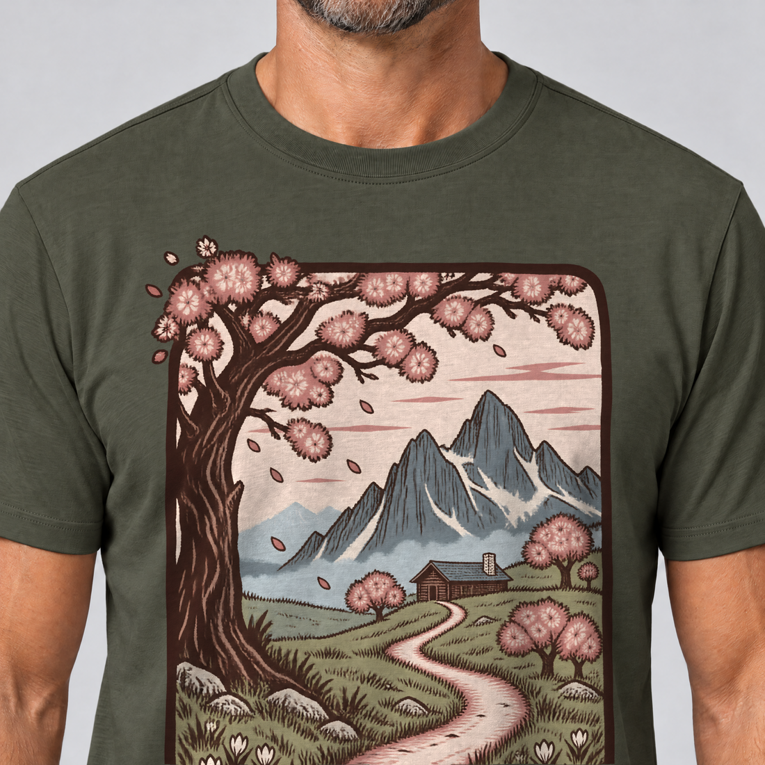 Nahaufnahme des Drucks: Almweg zur Hütte – T-Shirt Unisex in Oliv, von einem Mann getragen