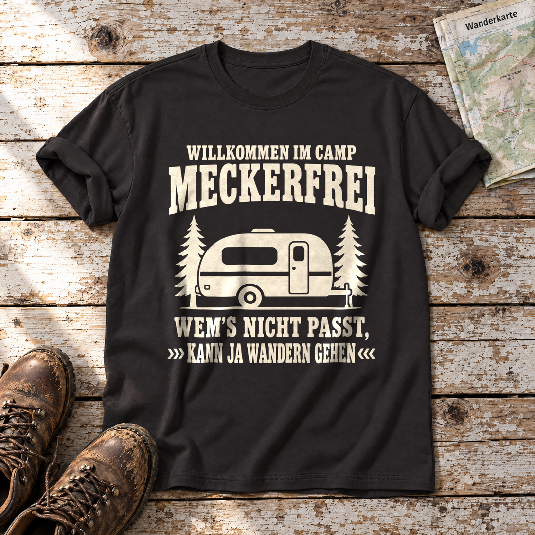 Kann ja wandern gehen – T-Shirt Unisex in Schwarz, flach liegend auf alten Holzbrettern mit Wanderschuhen und Wanderkarte.