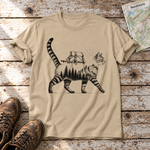 Katze mit Rucksack – T-Shirt Unisex in Sand, flach liegend auf alten Holzbrettern mit Wanderschuhen und Wanderkarte.