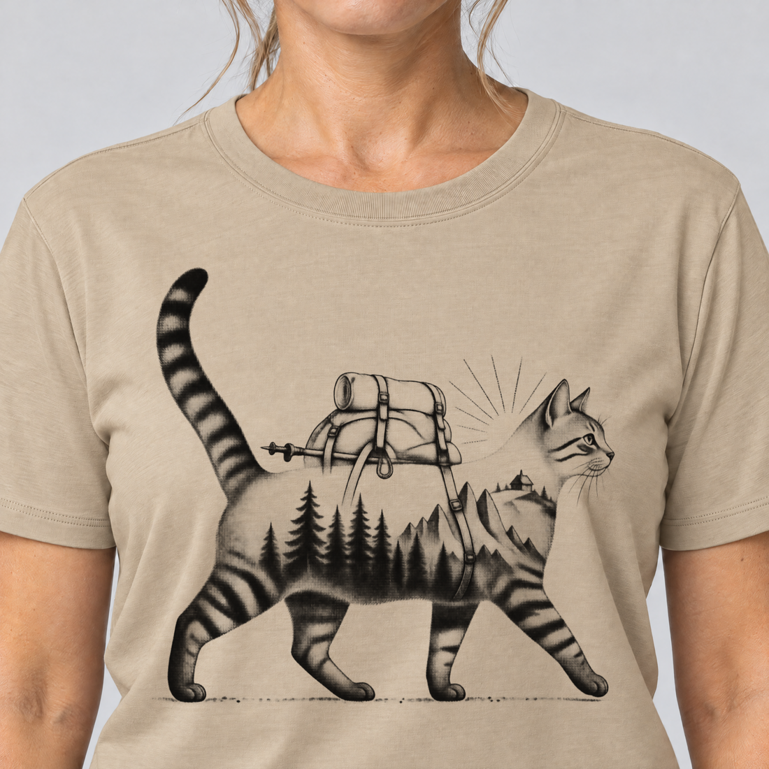 Nahaufnahme des Drucks: Katze mit Rucksack – T-Shirt Unisex in Sand, von einer Frau getragen
