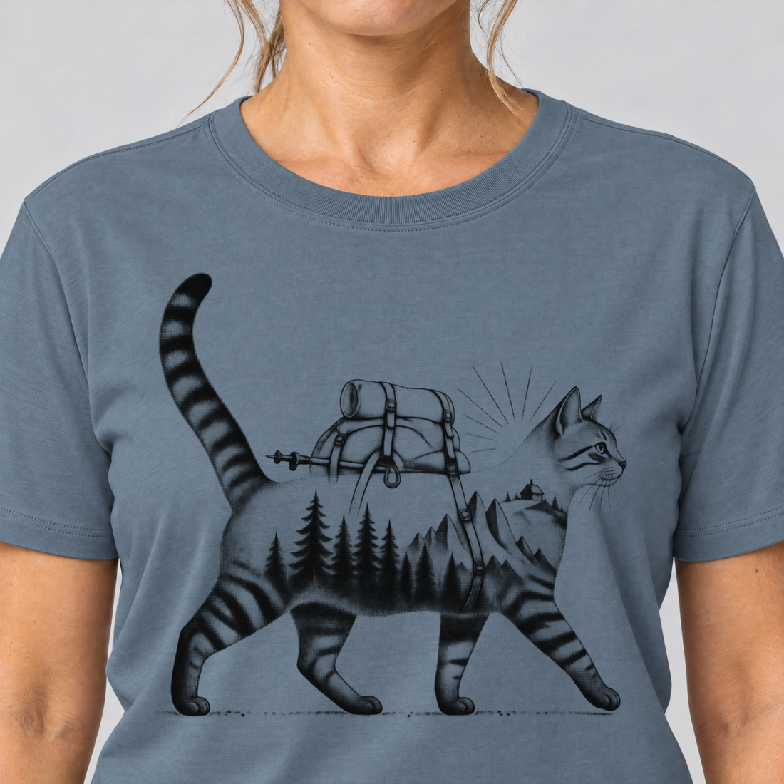 Nahaufnahme des Drucks: Katze mit Rucksack – T-Shirt Unisex in Steinblau, von einer Frau getragen