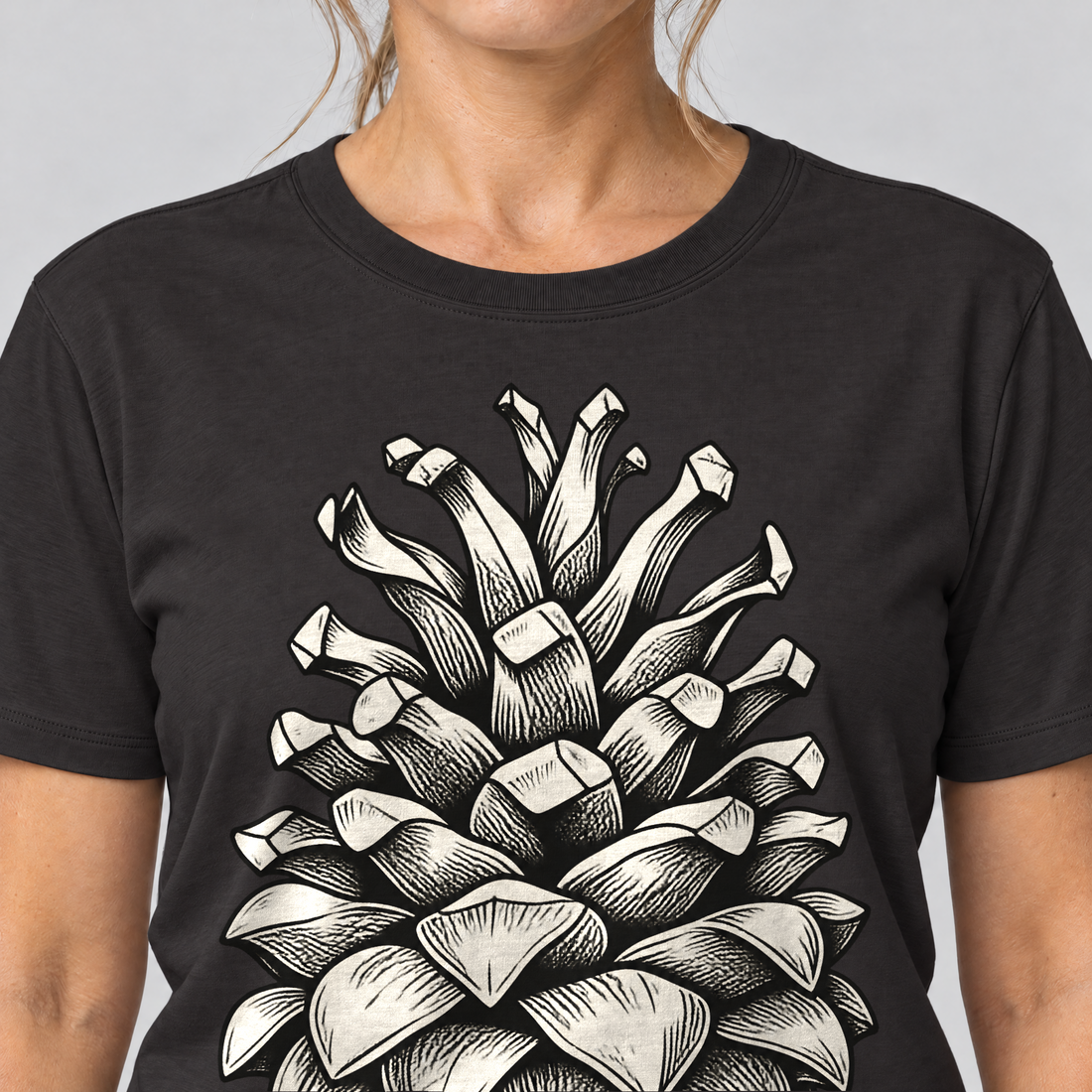 Nahaufnahme des Drucks: Kiefernzapfen – T-Shirt Unisex in Schwarz, von einer Frau getragen