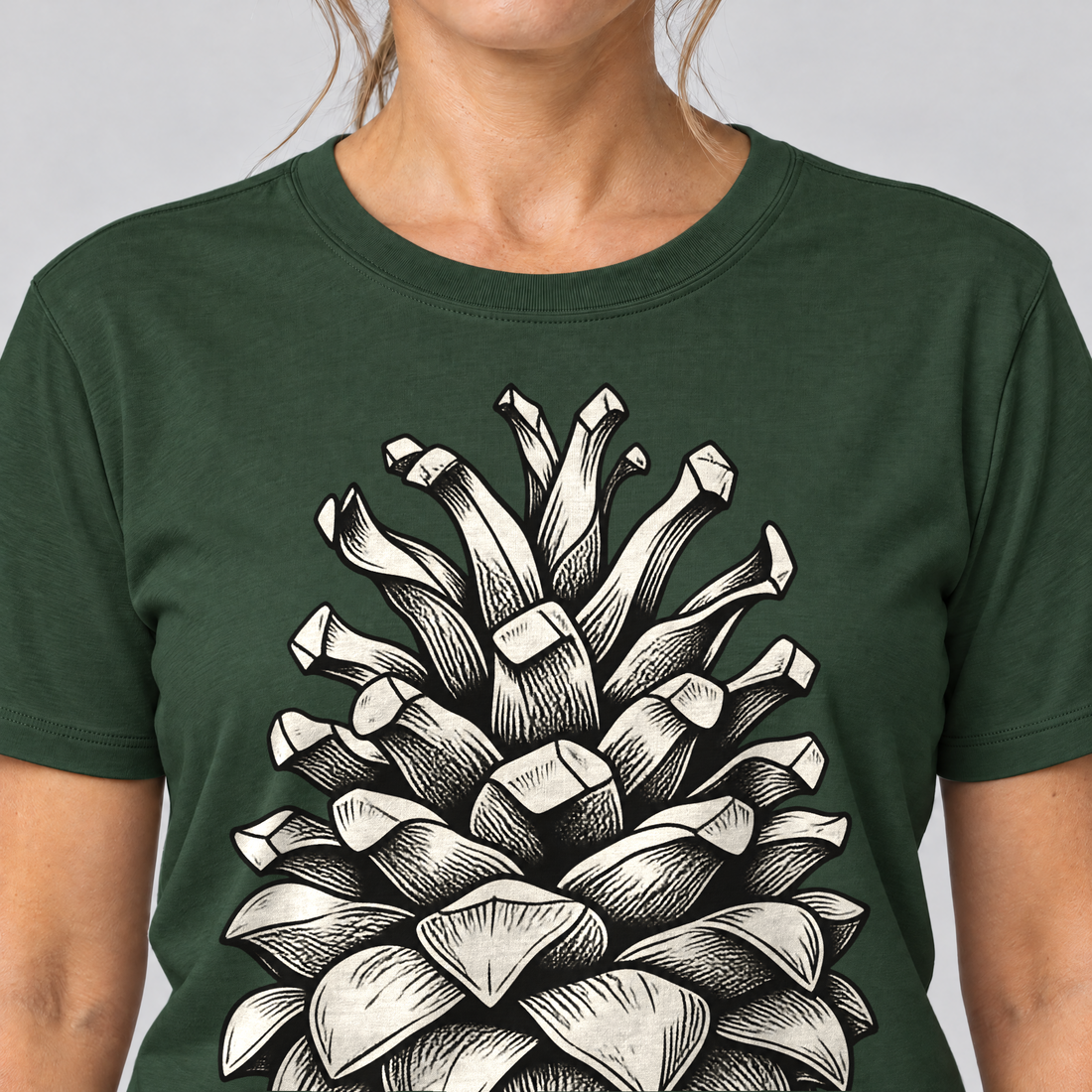 Nahaufnahme des Drucks: Kiefernzapfen – T-Shirt Unisex in Flaschengrün, von einer Frau getragen