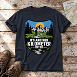 Another Kilometer or So – T-Shirt Unisex in Navy, flach liegend auf alten Holzbrettern mit Wanderschuhen und Wanderkarte.