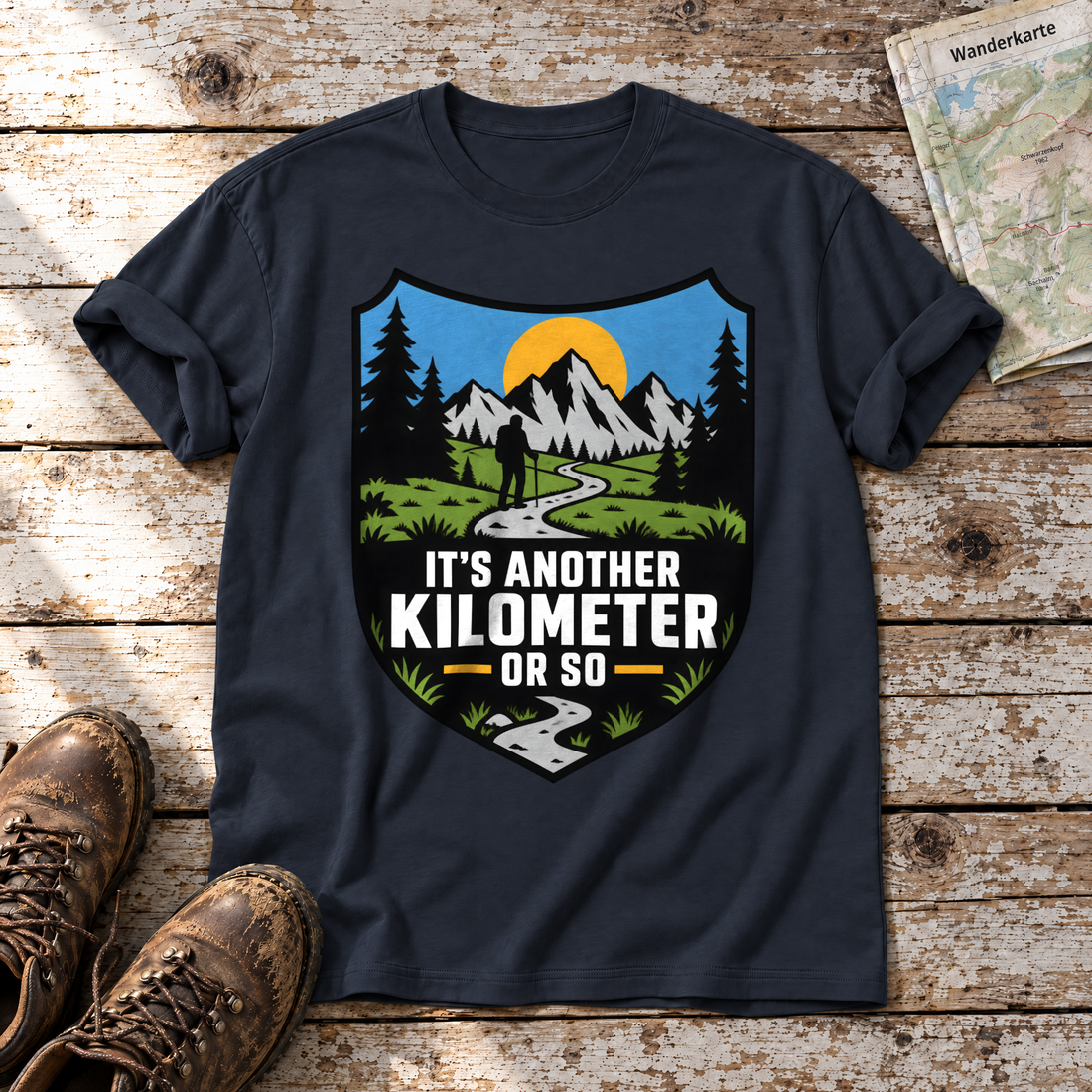 Another Kilometer or So – T-Shirt Unisex in Navy, flach liegend auf alten Holzbrettern mit Wanderschuhen und Wanderkarte.