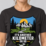 Nahaufnahme des Drucks: Another Kilometer or So – T-Shirt Unisex in Schwarz, von einer Frau getragen