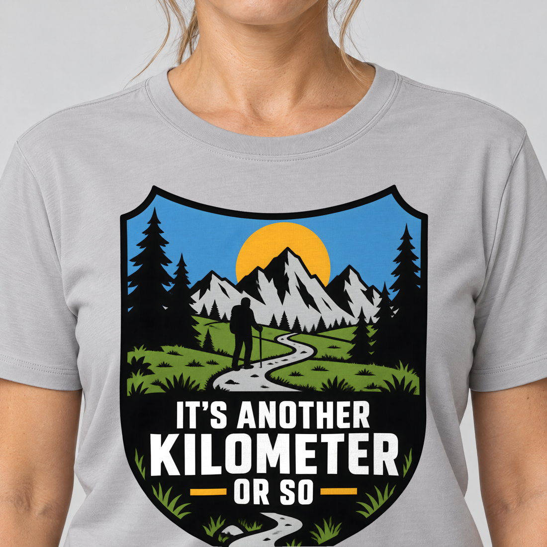 Nahaufnahme des Drucks: Another Kilometer or So – T-Shirt Unisex in Hellgrau, von einer Frau getragen