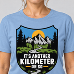 Nahaufnahme des Drucks: Another Kilometer or So – T-Shirt Unisex in Himmelblau, von einer Frau getragen