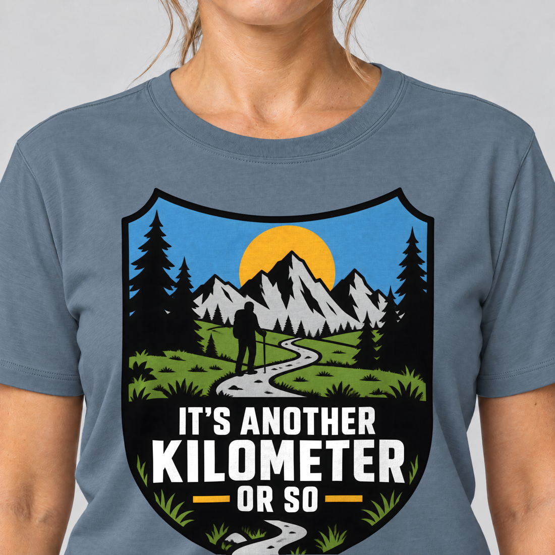 Nahaufnahme des Drucks: Another Kilometer or So – T-Shirt Unisex in Steinblau, von einer Frau getragen