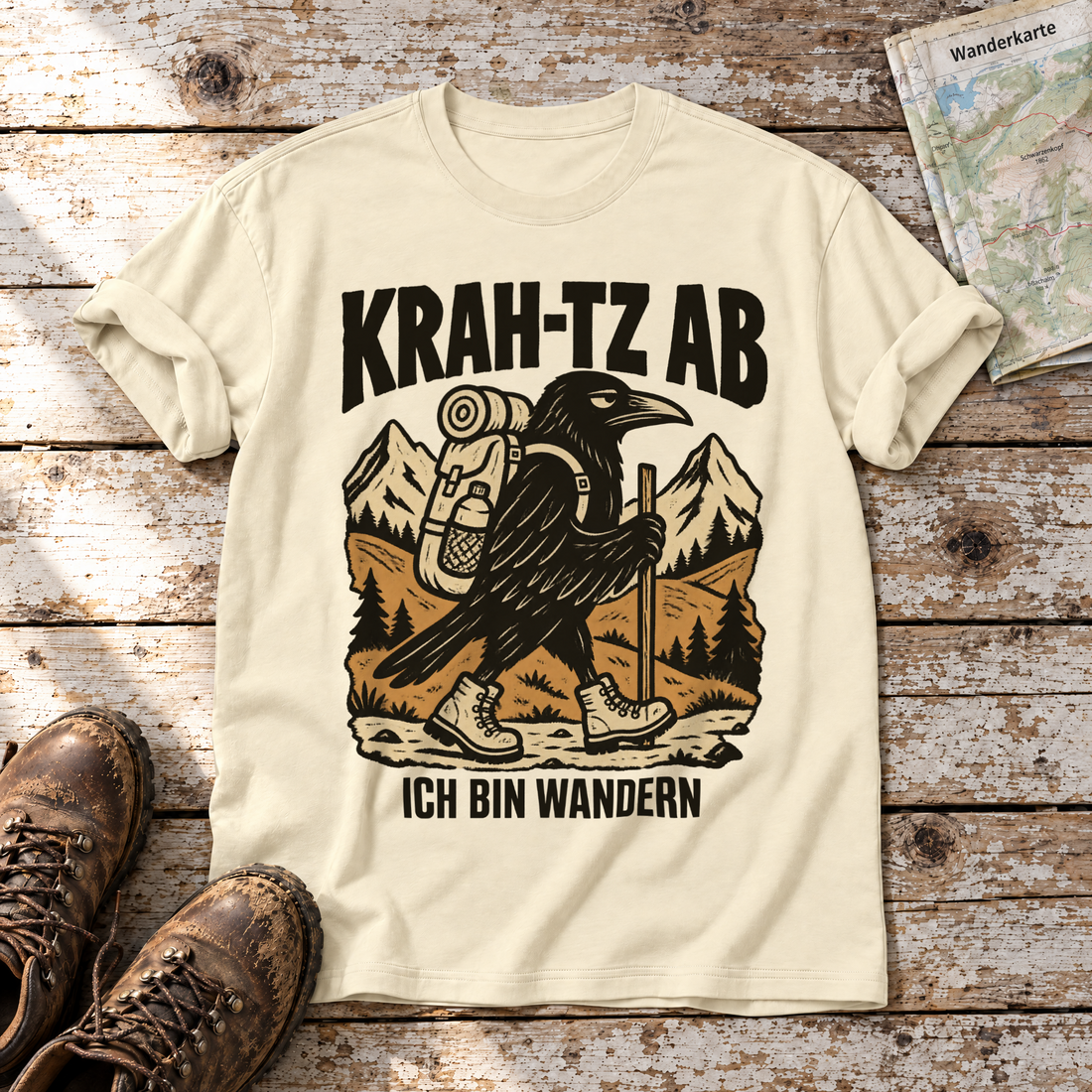 Krah-tz ab – T-Shirt Unisex in Natur, flach liegend auf alten Holzbrettern mit Wanderschuhen und Wanderkarte.