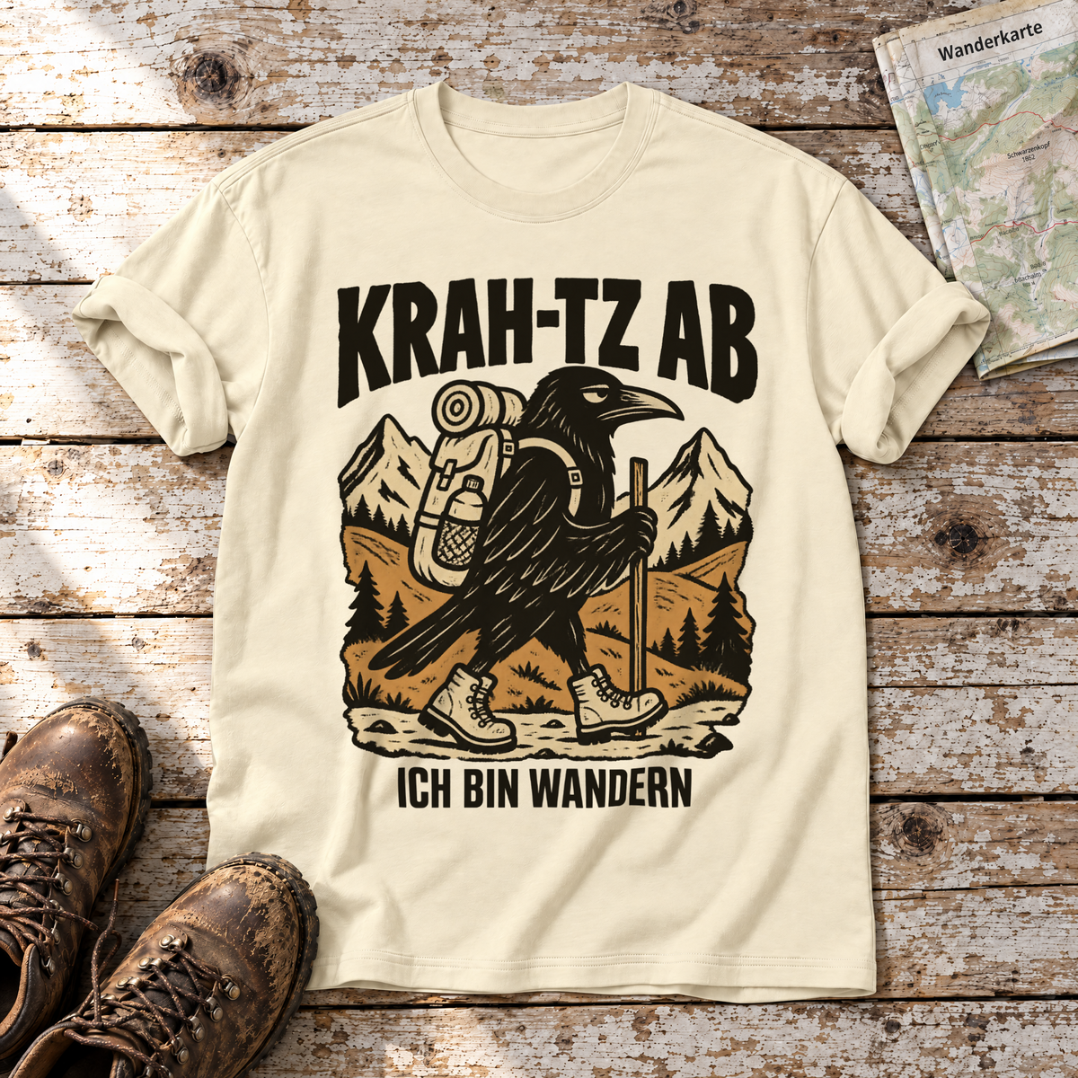 Krah-tz ab – T-Shirt Unisex in Natur, flach liegend auf alten Holzbrettern mit Wanderschuhen und Wanderkarte.
