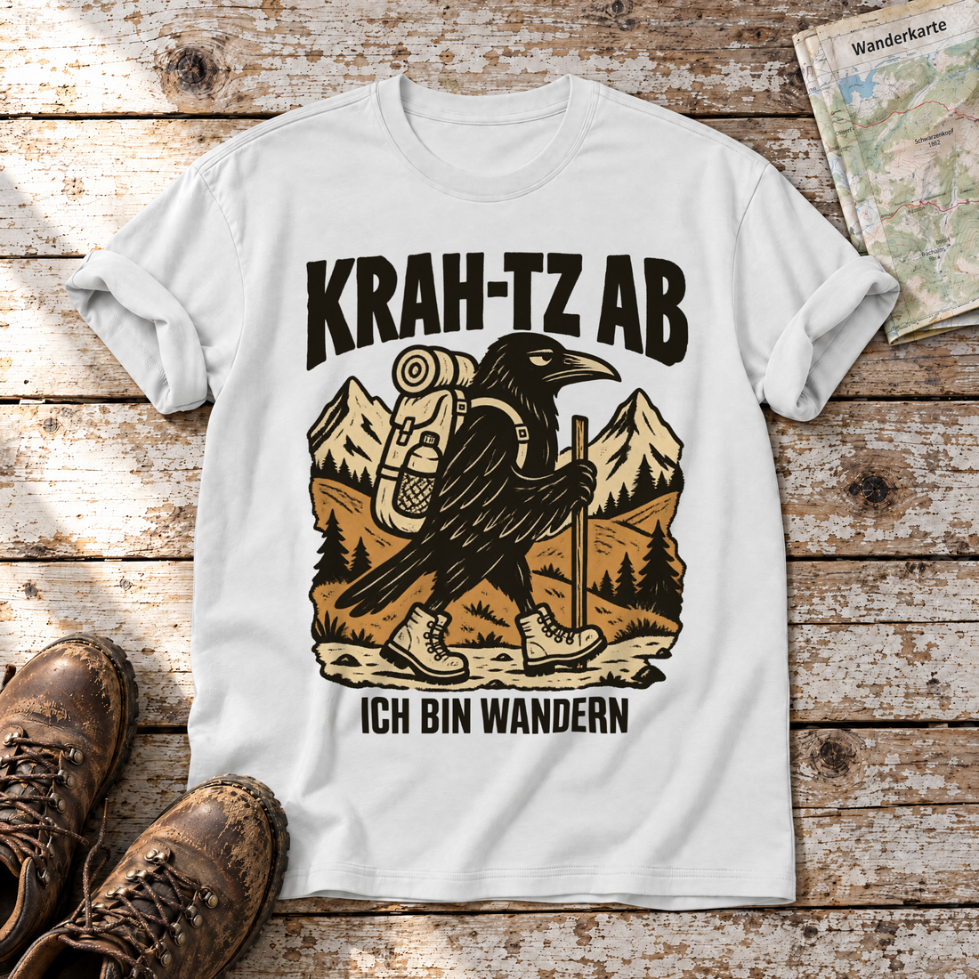Krah-tz ab – T-Shirt Unisex in Weiß, flach liegend auf alten Holzbrettern mit Wanderschuhen und Wanderkarte.