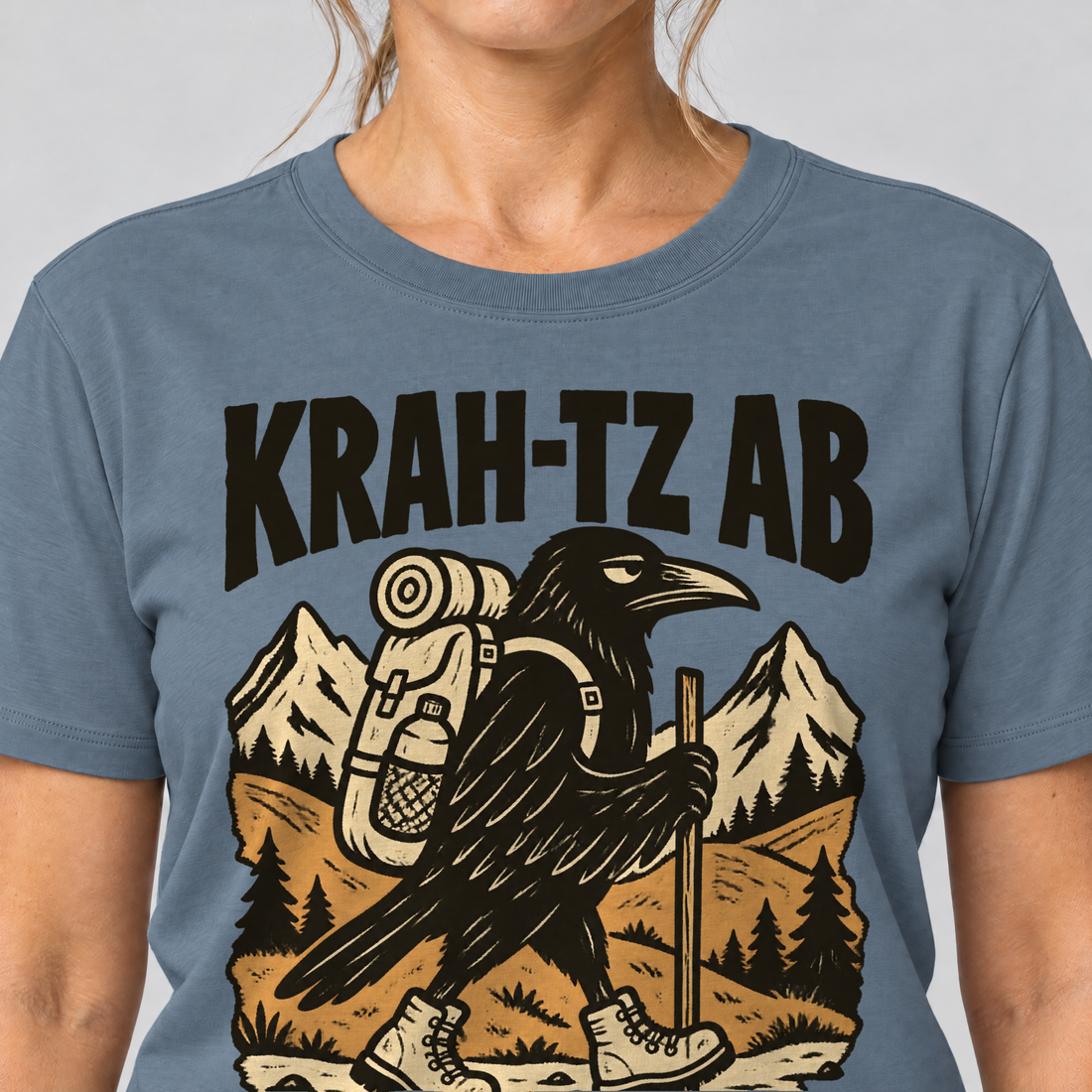 Nahaufnahme des Drucks: Krah-tz ab – T-Shirt Unisex in Steinblau, von einer Frau getragen