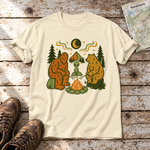 Bigfoot, Alien und Bär am Lagerfeuer – T-Shirt Unisex in Natur, flach liegend auf alten Holzbrettern mit Wanderschuhen und Wanderkarte.