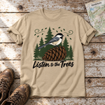 Listen to the Trees – T-Shirt Unisex in Sand, flach liegend auf alten Holzbrettern mit Wanderschuhen und Wanderkarte.
