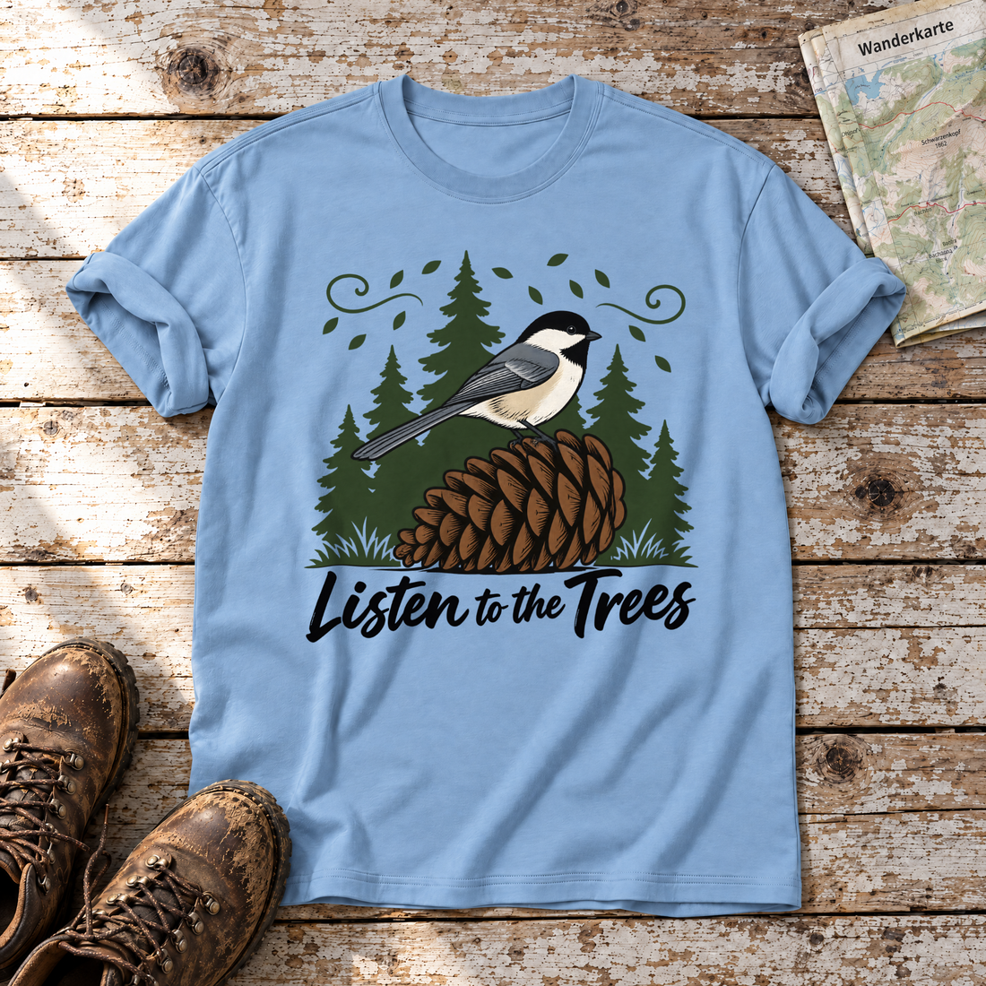 Listen to the Trees – T-Shirt Unisex in Himmelblau, flach liegend auf alten Holzbrettern mit Wanderschuhen und Wanderkarte.