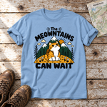 The Meowntains can wait – T-Shirt Unisex in Himmelblau, flach liegend auf alten Holzbrettern mit Wanderschuhen und Wanderkarte.