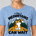 Nahaufnahme des Drucks: The Meowntains can wait – T-Shirt Unisex in Himmelblau, von einer Frau getragen