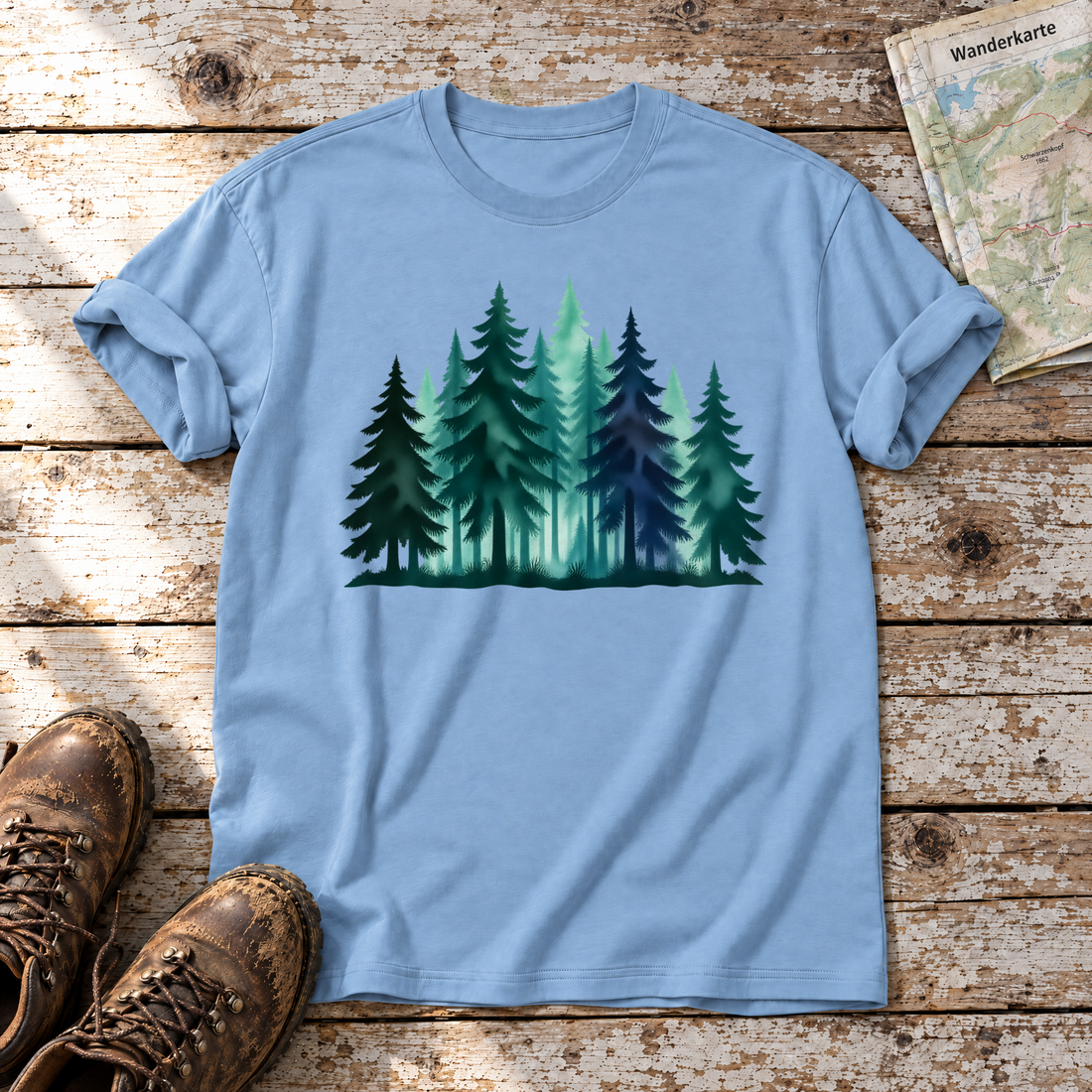 Nebelwald – T-Shirt Unisex in Himmelblau, flach liegend auf alten Holzbrettern mit Wanderschuhen und Wanderkarte.
