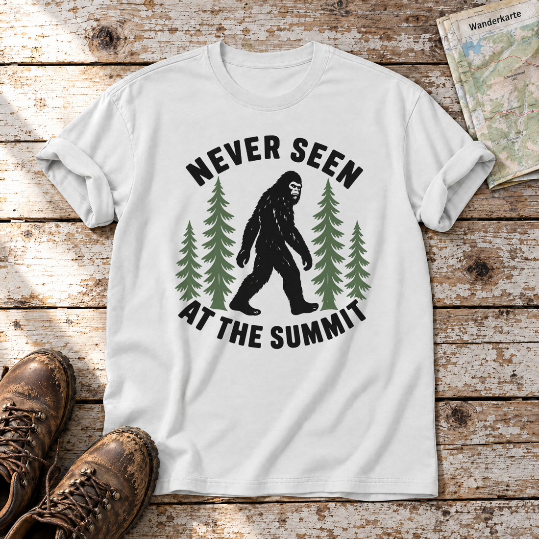 Never seen at the summit – T-Shirt Unisex in Weiß, flach liegend auf alten Holzbrettern mit Wanderschuhen und Wanderkarte.