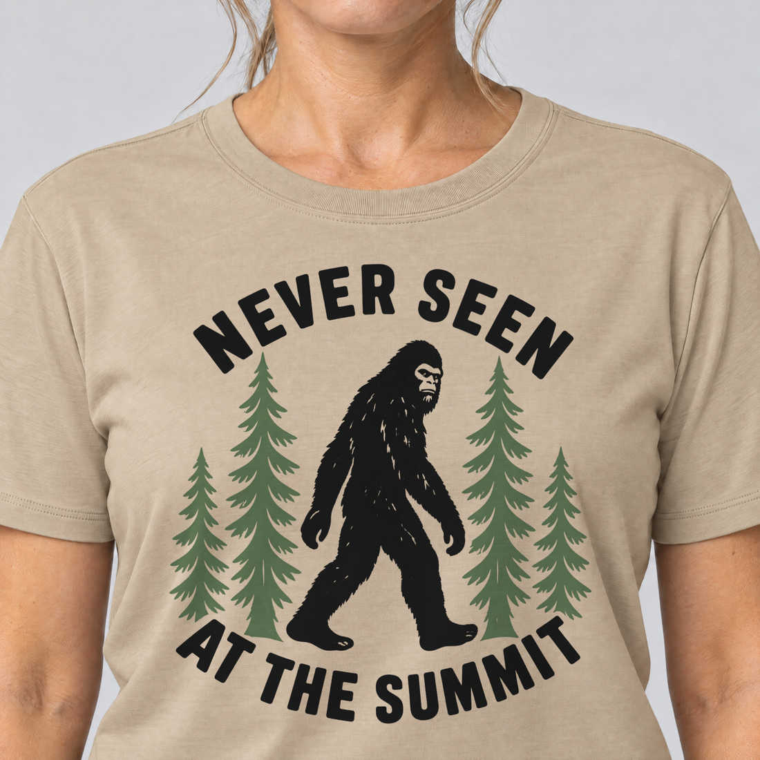 Nahaufnahme des Drucks: Never seen at the summit – T-Shirt Unisex in Sand, von einer Frau getragen